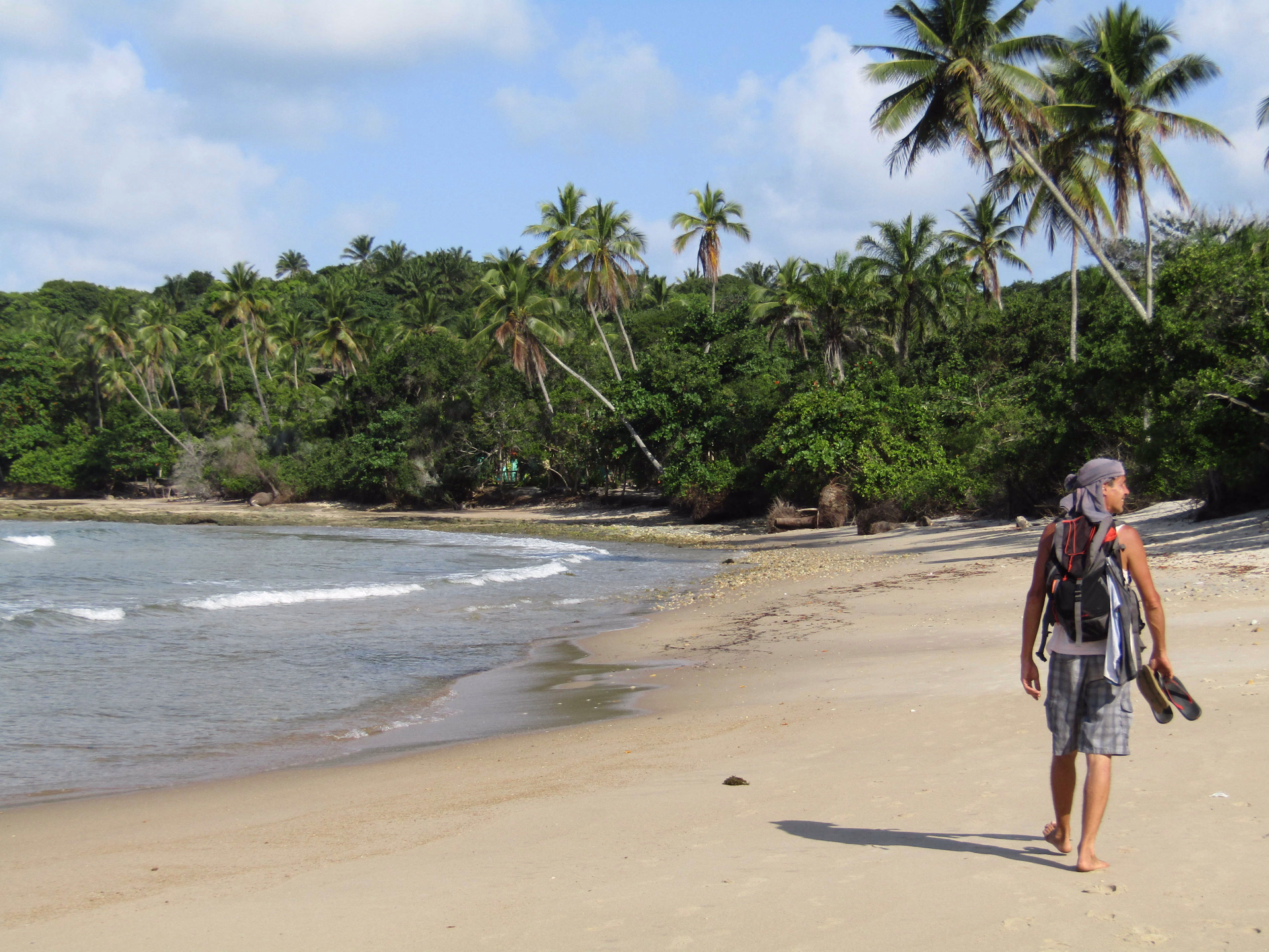 Homme marchant sur une plage de l'île de Boipeba