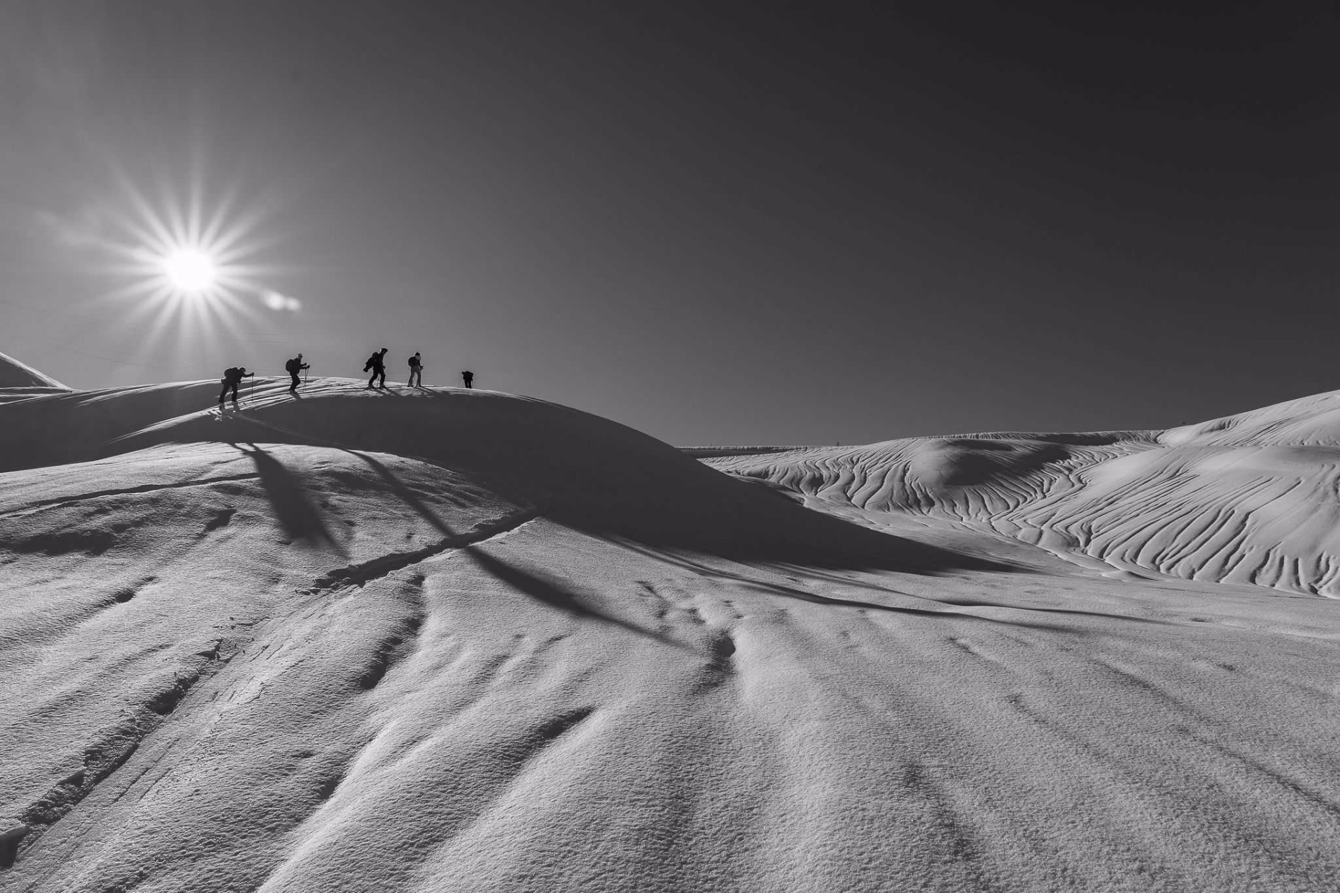 Skieurs de randonnée dans une plaine enneigée