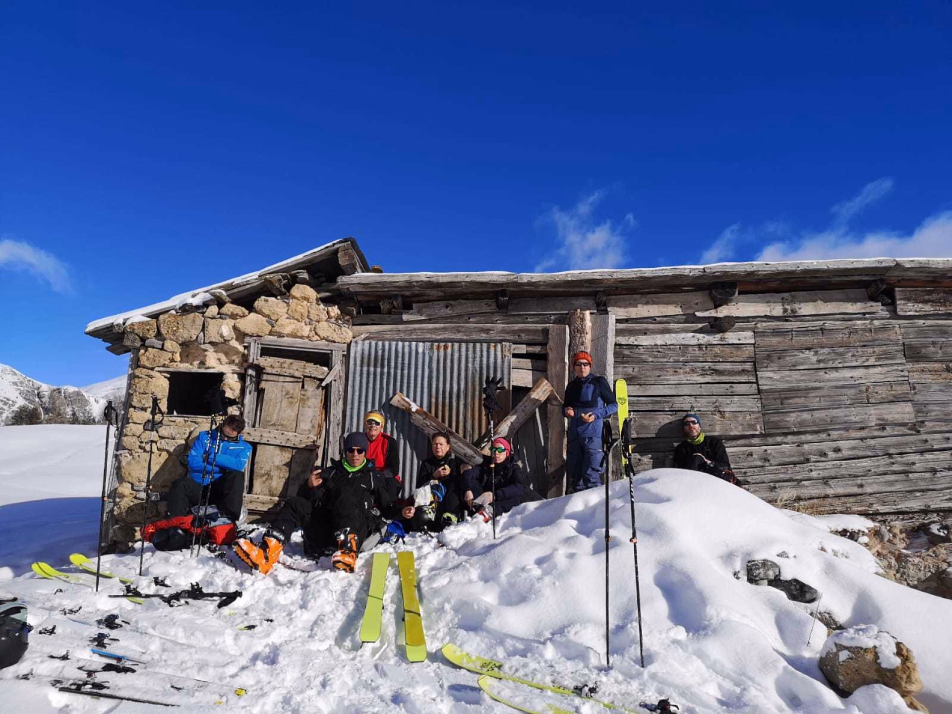 Skieurs de randonnée en pause contre une bergerie