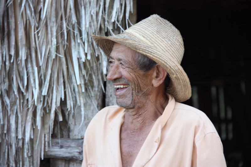 paysan devant un séchoir à tabac à Vinales