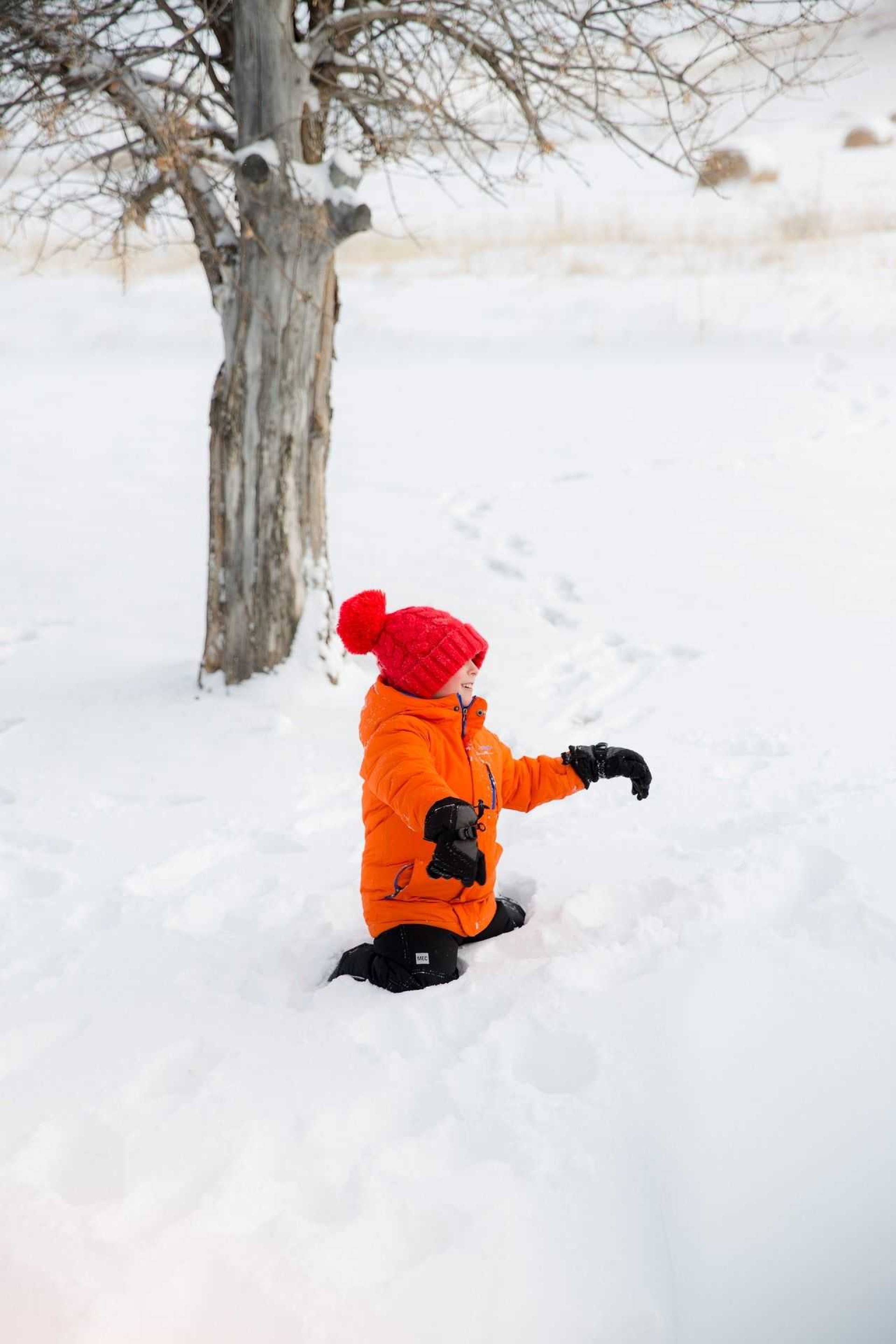 Enfant jouant dans la neige dans le Queyras lors d'une activité famille