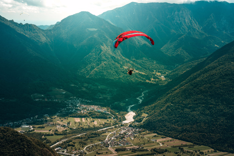 parapentiste au dessus de la vallée de le monêtier les bains avec vue sur les montagnes